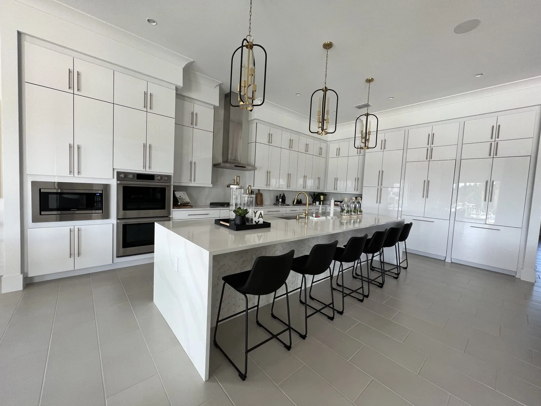 Frameless white high gloss kitchen with long island and black seating